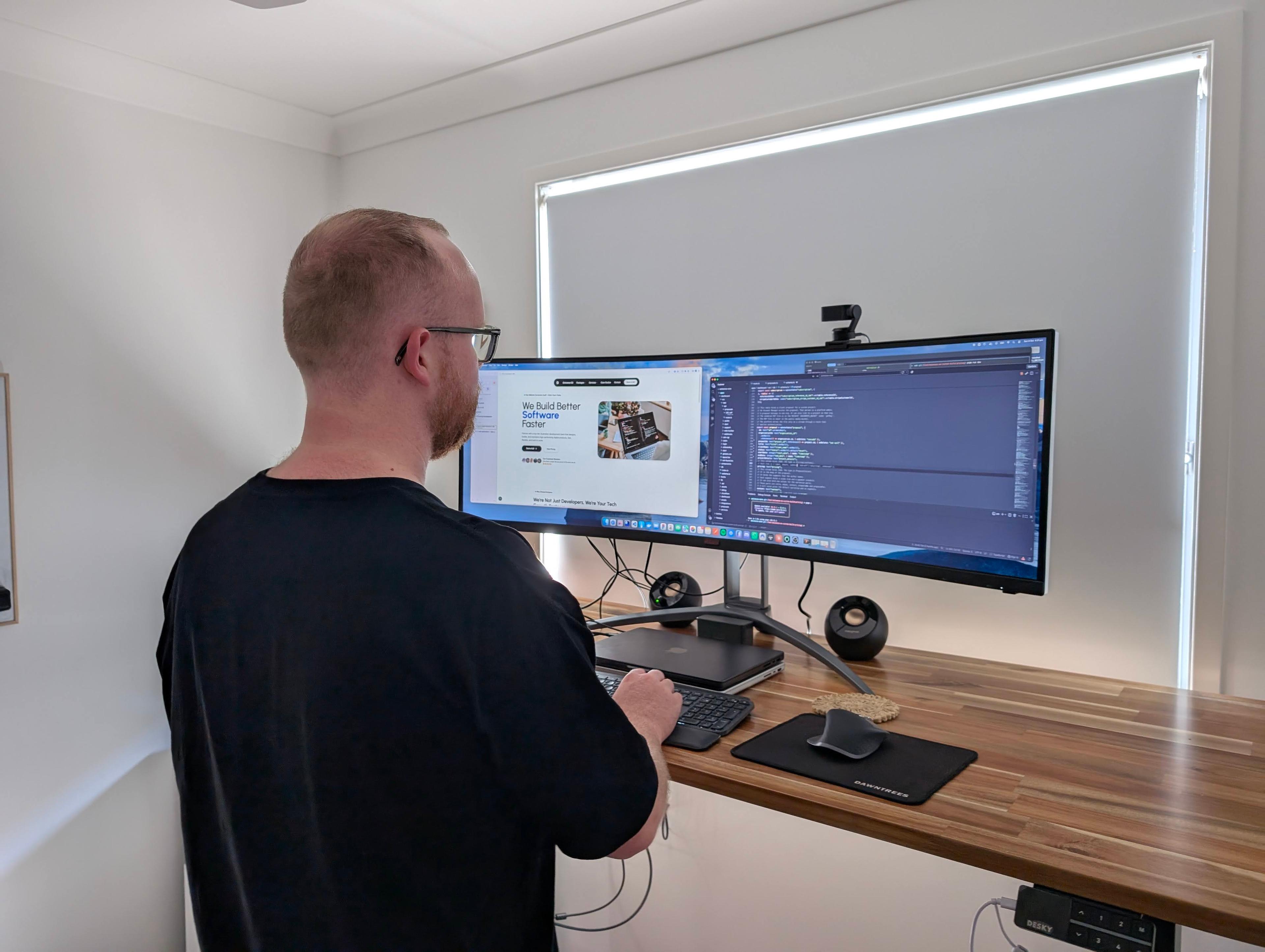 A developer building a client website at a dual-monitor desk setup